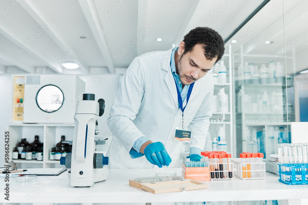 Poster i have to perfect this cure. shot of a young scientist working with samples in a lab.