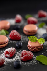 macaroons of different colors on a black background