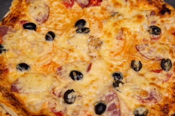 Pizza with olives pepper and cheese.