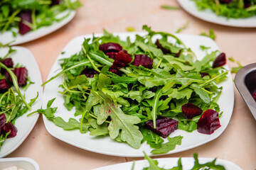 Salad with beetroot from arugula with cheese and pomegranate. Vegetarian food.