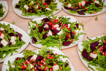 Naklejka premium Salad with beetroot from arugula with cheese and pomegranate. Vegetarian food.