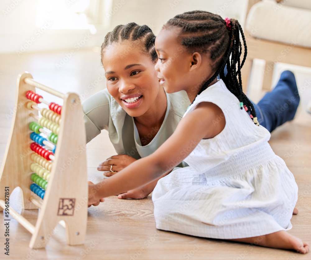 Canvas Prints African american mother lying on the wooden floor in the lunge at home smiling with her daughter while playing with educational toys. Adorable little girl playing while bonding and spending time with