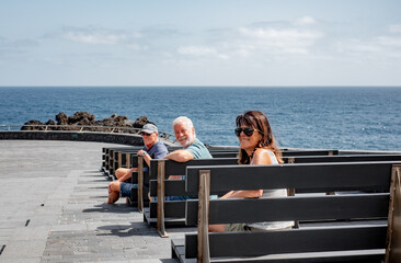 Group of Lonely Mature Old People Sitting Alone on Benches by the Sea, Looking at Camera Smiling, Relationship Difficulties, Lack of Communication, Loneliness