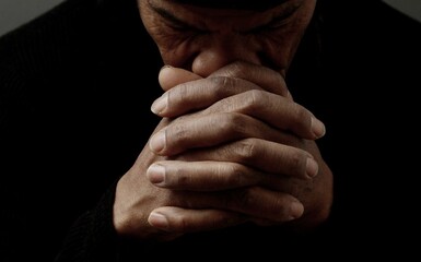 man praying to god with hands together Caribbean man praying with black background stock photos stock photo	