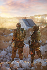 Naklejka premium airsoft. A man and a woman in camouflage with machine guns in their hands on the ruins.