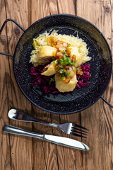 dumpllings filled with smoked meat served with red and white cabbage