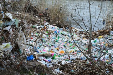 trash and plastic on the river bank