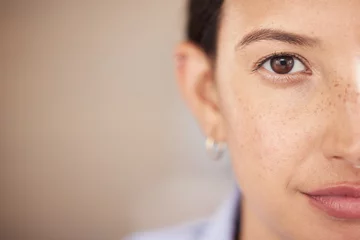 Fotobehang Closeup of mixed race womans eye and face with freckles split in half looking straight ahead at the camera. One female only staring in front of her. Confident woman focused on her goals and vision © Julia van der Westhuysen/peopleimages.com
