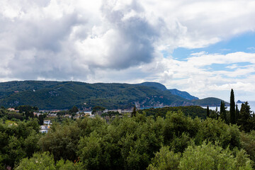 Fototapeta premium A beautiful landscape of the island of Corfu in the Ionian Sea in Greece. Mountains with plenty of green vegetation. Thick clouds over the island. 