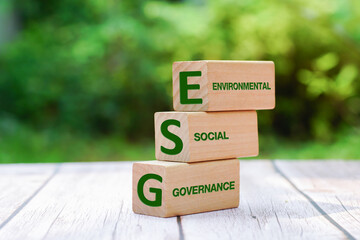 Words ESG on a wood block on soil natural green background. ESG concept of environmental, social and governance idea for sustainable modernization development.