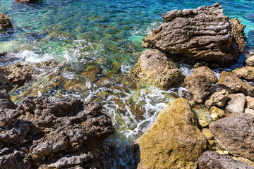 A beautiful landscape of the coast of the island of Corfu in the Ionian Sea of the Mediterranean in Greece. Pure blue clear water washes over the shores of the Greek island.