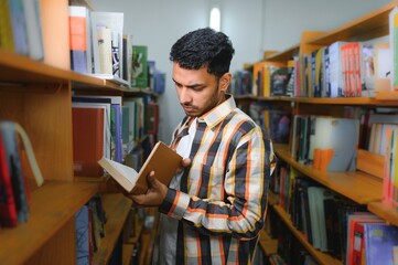 Happy smart indian or arabian guy, mixed race male, university student, in the library