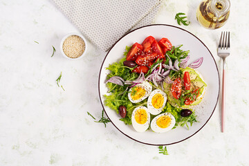 Fresh  salad with tomato, olives, boiled eggs and and sandwich with  ricotta cheese, avocado. Top view, flat lay