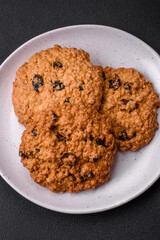 Delicious baked oatmeal raisin cookies on a dark concrete background