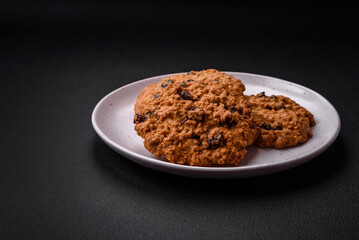 Delicious baked oatmeal raisin cookies on a dark concrete background