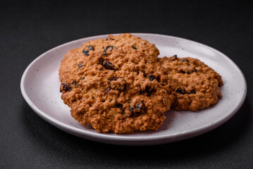 Delicious baked oatmeal raisin cookies on a dark concrete background