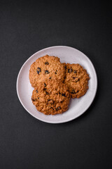Delicious baked oatmeal raisin cookies on a dark concrete background