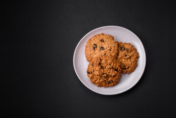 Delicious baked oatmeal raisin cookies on a dark concrete background