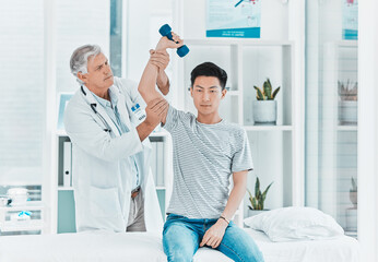 Fototapeta premium Hes been working on his strength. Shot of a mature doctor testing his patients strength.