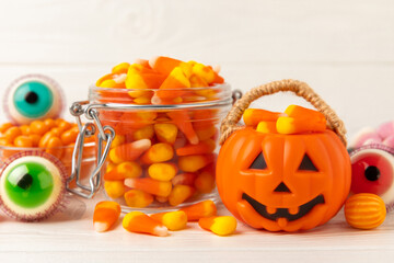 Halloween candy on a white background. coffee corn and sazar skull.Halloween holiday background with jack o lantern pumpkin, candy corn and decorations.Top view.Flat lay. Place for text.