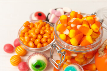 Halloween candy on a white background. coffee corn and sazar skull.Halloween holiday background with jack o lantern pumpkin, candy corn and decorations.Top view.Flat lay. Place for text.