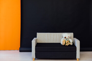 sofa with a bear with flowers on a black background interior in the room