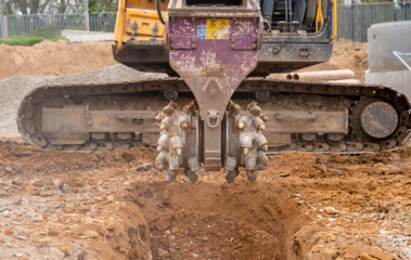 Rotating milling drum close-up. A digger with a hydraulic rockwheel breaking up rock for the...