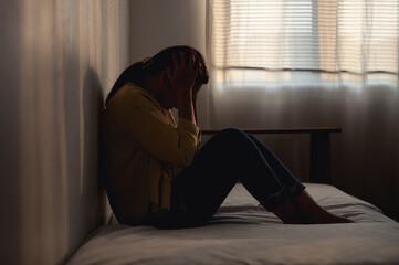 Silhouette photo of young Asian woman feeling upset, sad, unhappy or disappoint crying lonely in...