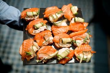 High quality photo of bruschetta with cream cheese ,salmon and slices of cucumber on metallic salver