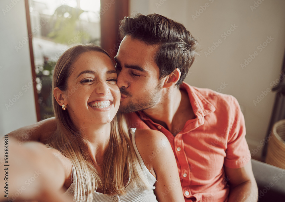 Poster making memories every day. shot of a young couple taking a selfie together at home.