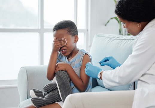 How sore will it be. Shot of a little boy looking scared while getting an injection on his arm from a doctor.