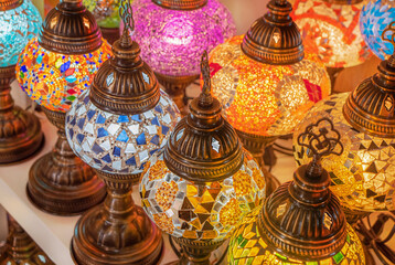 Fototapeta na wymiar Multi-colored, bright lamps made of glass close-up to illuminate the home's rooms. Traditional Turkish souvenir lamps. Decorative products made of colored glass. Comfort at home.