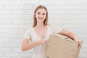 Pretty young woman with cardboard box. Delivering a parcel