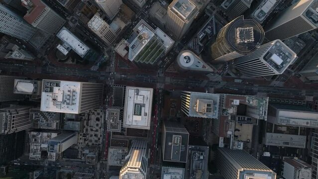 Fly above downtown skyscrapers in Financial District at dusk. Top down footage of street grid and blocks of high rise buildings.