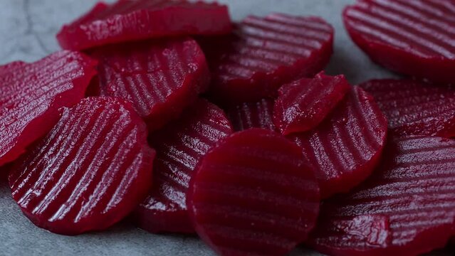 Slices of pickled red beets on black background