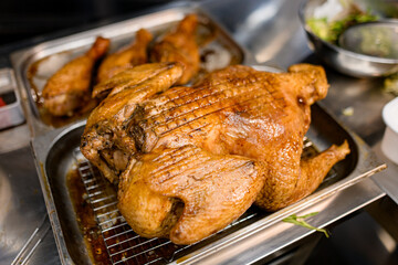 Closeup photo of tasty roasted chicken and chicken legs on blurred background