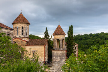 Fototapeta na wymiar Motsameta monastery, XI century medieval stone orthodox church located on a cliff among lush forests in Georgia, Imereti Region.