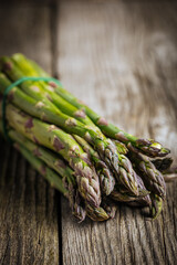 Bunch of green asparagus on rustic wooden board. Fresh and seasonal ingredient.