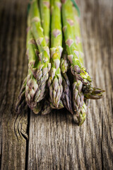 Bunch of green asparagus on rustic wooden board. Fresh and seasonal ingredient.