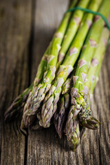 Bunch of green asparagus on rustic wooden board. Fresh and seasonal ingredient.