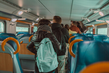 Back view of crowded caucasian people queue for to exit from public train during rush hour. High quality photo