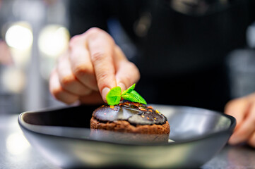 chef decorated Basque cheesecake with Chocolate and cream in bowl on kitchen