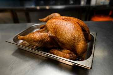 Side view on roasted chicken in soy sauce with tasty crust on metallic salver