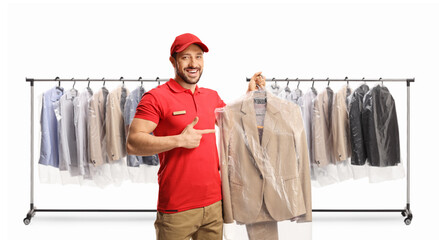 Clothing racks and a dry cleaning worker holding a suit on a hanger with a plastic cover