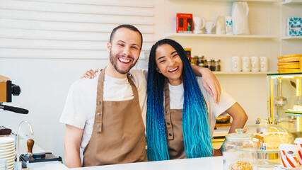 Happy man and woman are working in coffee shop together