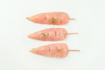Chicken skewers.Food concept.Skewers from raw chicken meat inner fillet for a supermarket on a white background.Ogranic food,healthy eating.Food for retail.Top view.
