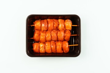 Fresh raw marinated chicken leg meat skewers without skin on a white background.Marinated Fresh,raw chicken in the package.Closeup of chicken meat.Procurement for designers.