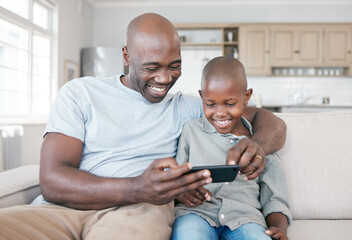 Home is where you are loved. Shot of a father and son using a cellphone on the sofa at home.