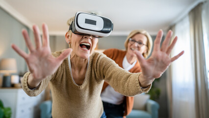 Women two senior females at home enjoy virtual reality VR headset