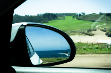 Looking at the sea from the rear-view mirror of our car, summer holidays